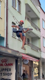 Eşyalarını taşıdığı halatın üzerinde gitar çalıp, şarkı söyledi