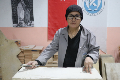 Hat sanatı hocası, tarihi Rum Yetimhanesi'nin bahçesinde kurulan atölyede taşa şekil veriyor