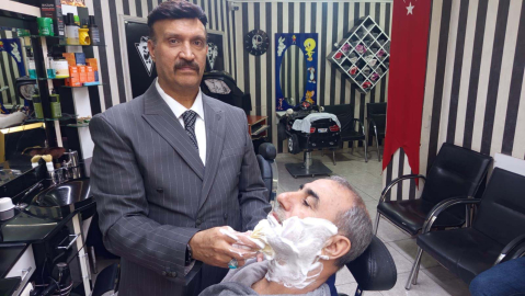 Mesleğine aşık berber, müşterilerini takım elbise ile tıraş ediyor