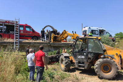 Köprüden düşen traktörün altında kalan sürücü iş makinesiyle kurtarıldı